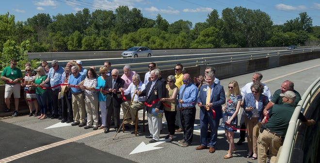 The red ribbon is cut on the Wil-Cox Pedestrian Bridge to mark the opening of the new Yadkin River Park on Friday morning. See more photos in a gallery at www.the-dispatch.com. [Donnie Roberts/The Dispatch]