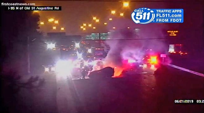 Two vehicles that hit each other head-on just before 3 a.m. Friday burn on Interstate 95 south in Mandarin, as seen on an FDOT traffic camera. [FDOT/First Coast News]