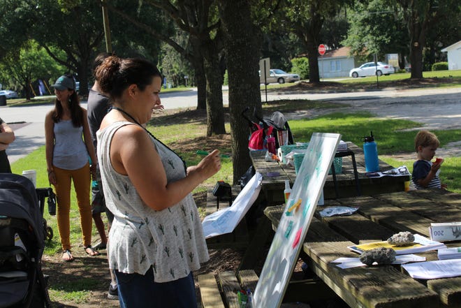 An attendee writes on a sticky note her experience with a perinatal mood and anxiety disorder on the "I'm Climbing For" board. [Brittini Ray/ savannahnow.com]