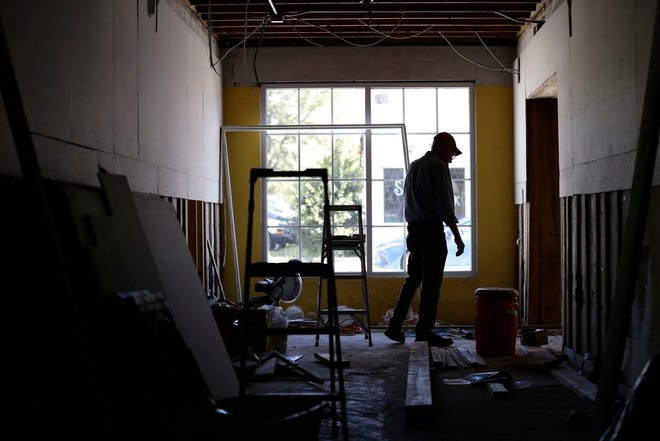In this photo taken Wednesday, April 17, 2019 in Trenton, N.C., town manager Glenn Spivey looks through a store undergoing repairs following the lasting effects of Hurricane Florence. Eight months after the storm inundated North Carolina, communities such as Trenton illustrate the slow and uneven pace of recovery.(AP Photo/Gerry Broome)