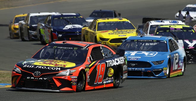 Martin Truex Jr. (19) leads the pack through a turn during a NASCAR Sprint Cup Series auto race on Sunday in Sonoma, Calif. [Ben Margot/The Associated Press]