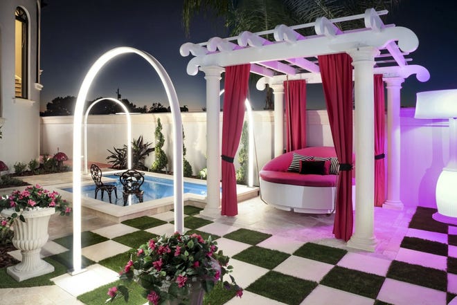 Tampa-based designer Ryan Hughes for this outdoor space took inspiration from the homeowner's daughter's love of "Alice in Wonderland" to create a playful, over-the-top outdoor space complete with unique lighting effects, a hanging bed and oversized checkerboard. [The Associated Press]