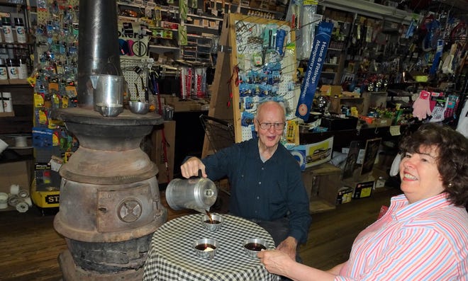 Leon Morgan, owner of M.A. Pace General Store in Saluda, and Janie Mae enjoy Granny and Grandpaís favorite Maxwell House coffee. The brand was highly advertised on old-fashioned radio programs. For effect, Mr. Morgan pours from a stove-top, coffee pot like her grandparents used on Bear Mountain. [Photo by Larry McKinley]