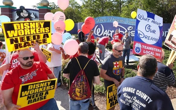 Union workers demonstrating in March in front of a Disney hotel in Orlando, Fla. Members will vote on the new contract, which stipulates gradual minimum wage increases, on Sept. 5 and 6. [Stephen M. Dowell/Orlando Sentinel, via Associated Press]