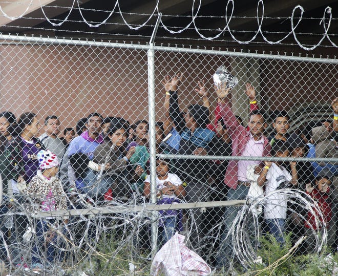 Central American migrants are shown in March, waiting for food in a pen erected by U.S. Customs and Border Protection to process a surge of migrant families and unaccompanied minors in El Paso. [AP Photo/Cedar Attanasio, File]
