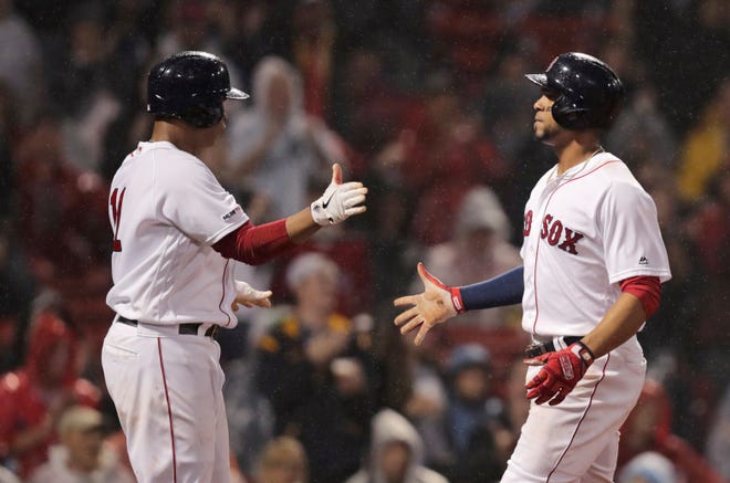 Boston Red Sox's Xander Bogaerts, right, and Rafael Devers celebrate after scoring on a Christian Vazquez two-RBI single during the third inning of a baseball game against the Chicago White Sox at Fenway Park in Boston, Tuesday, June 25, 2019.(AP Photo/Charles Krupa)