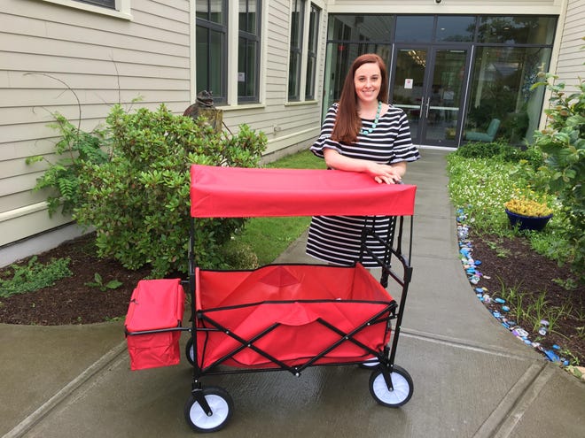 Catherine Damiani, director of Tiverton Library Services, shows off a cart donated by Friends of the Tiverton Libraries that will be rolled out at Grinnell’s Beach beginning next week for beach visitors to “take a book, leave a book.” [Newport Daily New photo]