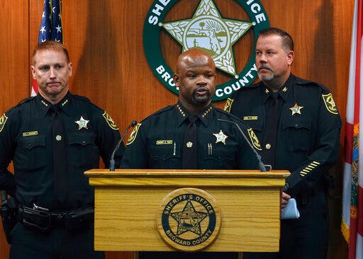 Broward Sheriff Gregory Tony, center, announces that two additional deputies have been fired as a result of the agency's internal affairs investigation into the mass shooting at Marjory Stoneman Douglas High School in Parkland, at the Broward Sheriff's Office headquarters in Fort Lauderdale, Fla., Wednesday, June 26, 2019. Tony said deputies Edward Eason and Josh Stambaugh were fired Tuesday for their inaction following the Feb. 14, 2018 shooting. (Joe Cavaretta/South Florida Sun-Sentinel via AP)