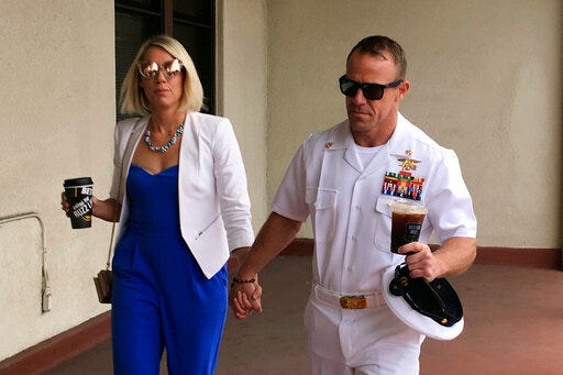Navy Special Operations Chief Edward Gallagher, right, walks with his wife, Andrea Gallagher as they arrive to military court on Naval Base San Diego, Wednesday, June 26, 2019, in San Diego. Trial continues in the court-martial of the decorated Navy SEAL, who is accused of stabbing to death a wounded teenage Islamic State prisoner and wounding two civilians in Iraq in 2017. He has pleaded not guilty to murder and attempted murder, charges that carry a potential life sentence. (AP Photo/Julie Watson)
