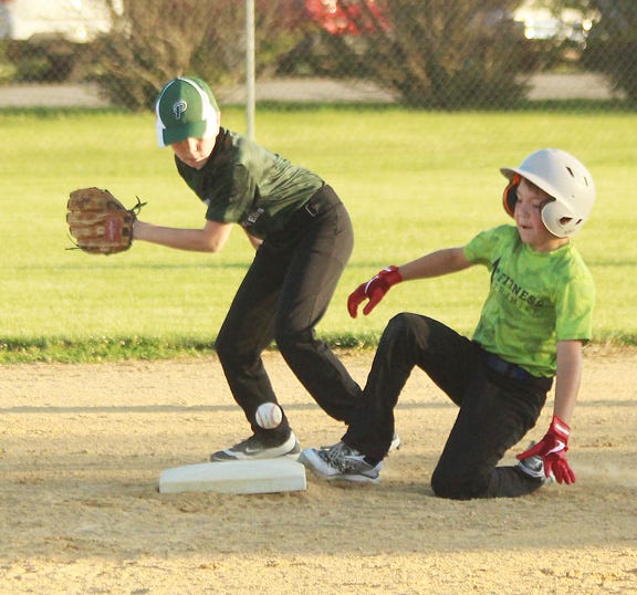 Cale Christenson of Fitness Premier slides safely into second base as the ball gets away from Country Financial second baseman Durham Fenton during Little League tournament play Tuesday at the Rec-Plex.