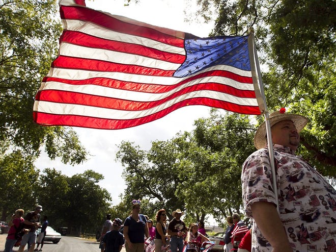 Chris Appice carries an American flag during the 2012 Georgetown Fourth of July Hometown Parade at San Gabriel Park. [Rodolfo Gonzalez/American Statesman]