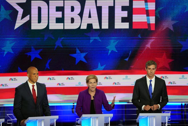 Sen. Elizabeth Warren (D-Mass.) is flanked by Sen. Cory Booker (D-N.J.), left, and former Representative Beto O'Rourke of Texas as she speaks during the first Democratic presidential debate in Miami on Wednesday. [Doug Mills/The New York Times]