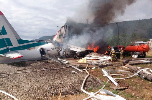 In this photo provided by Russian Emergency Situations Ministry for the Republic of Buryatia Press Service, emergency services attend the crash scene of an An-24 plane of Angara Airlines in Nizhneangarsk, Republic of Buryatia, Russia, Thursday, June 27, 2019. Officials said at least two people died and over twenty are injured after a plane skidded off the runway in Nizhneangarsk, Russia's south east region. (Ministry of Emergency Situations for the Republic of Buryatia press service via AP)