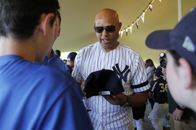 Former Yankee Mariano Rivera signs baseball cap for young fans in London on Thursday.

[Frank Augstein/Associated Press]