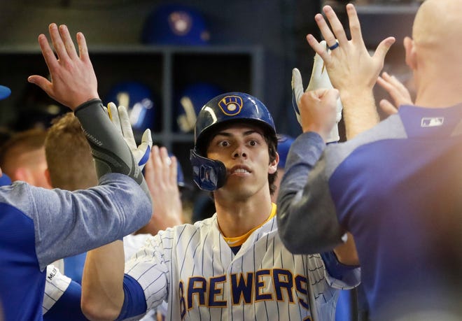 Milwaukee Brewers' Christian Yelich is congratulated after hitting a two-run home run during the fifth inning of a baseball game against the Cincinnati Reds Friday, June 21, 2019, in Milwaukee. (AP Photo/Morry Gash)