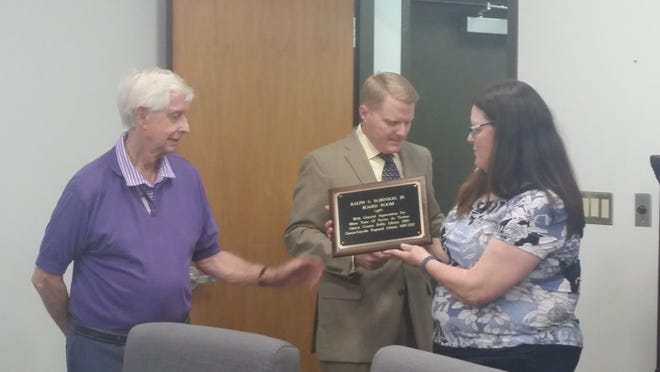 Board Chair J. Brett Keeter and Library Director Laurel Morris present Ralph Robinson Jr. with a plaque that officially names the newly renovated library board room as the “Ralph S. Robinson Jr. Board Room.” [GASTON COUNTY PUBLIC LIBRARY PHOTO]
