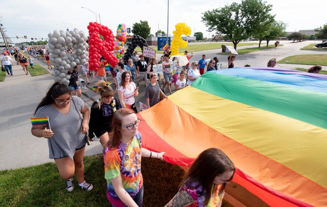 Marchers parade down Lorraine Street with a giant rainbow flag in Hutchinson's first "March for Equality," Saturday, June 9, 2018. [Jesse Brothers/HutchNews]