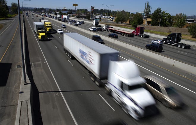 FILE - In this Wednesday, Aug. 24, 2016, file photo, truck and automobile traffic mix on Interstate 5, headed north through Fife, Wash., near the Port of Tacoma. Two U.S. senators have introduced a bill that would electronically limit tractor-trailer speeds to 65 miles per hour, a move they say would save lives on the nationþÄôs highways. Georgia Republican Johnny Isakson and Delaware Democrat Chris Coons introduced the measure Thursday, June 27, 2019. (AP Photo/Ted S. Warren, File)