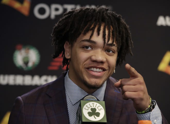 Boston Celtics 2019 NBA basketball draft player, Carsen Edwards, points out his family at a news conference to introduce the new team players on Monday in Boston. [AP File Photo/Elise Amendola]