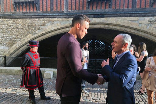 New York Yankees baseball player Aaron Judge shakes hands with baseball commissioner Ron Manfred, right, outside the Tower of London, Friday, June 28, 2019. The Boston Red Sox and New York Yankees are in London to play two games this weekend. (AP Photo/Ron Blum)