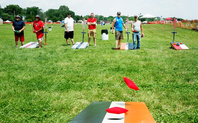 Participants in the Cornhole Tournament practice at Ashland BalloonFest on Saturday at Freer Field. It was a double-elimination tournament where everyone is guaranteed to play at least three games with $200 going to the winning team.