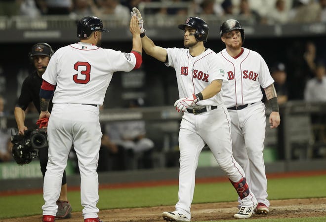 Boston Red Sox's Michael Chavis (center) celebrates his three-run home run with Sandy Leon (left) against the New York Yankees during the seventh inning on Saturday in London. Major League Baseball made its European debut Saturday at London Stadium. [AP Photo/Tim Ireland]