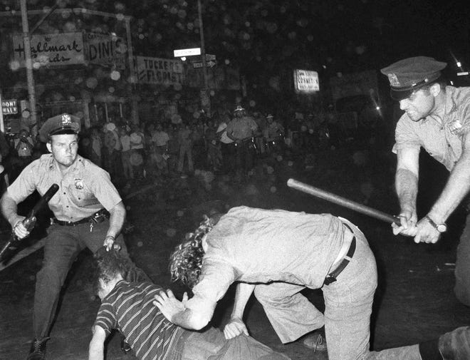 In this Aug. 31, 1970 photo, a New York Police Department officer grabs a youth by the hair as another officer clubs a young man during a confrontation in Greenwich Village after a Gay Power march in New York. [AP PHOTO/FILE]