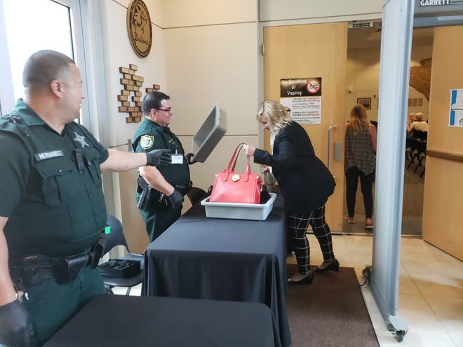 Deltona Mayor Heidi Herzberg collects her belongings after going through the city's new metal detector ahead of the City Commission meeting Monday. [NEWS-JOURNAL/KATIE KUSTURA]