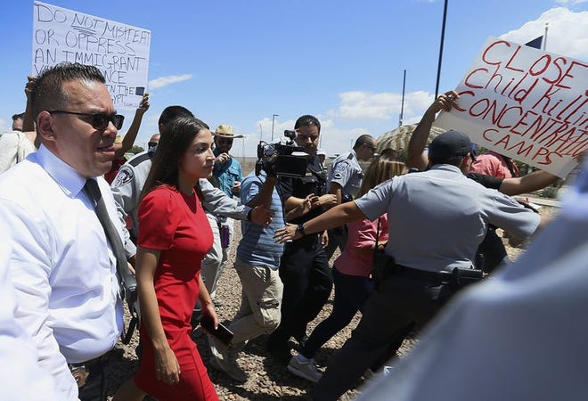 U.S. Rep. Alexandria Ocasio-Cortez, D-New York, is escorted back to her vehicle after she speaks at the Border Patrol station in Clint, Texas, about what she saw at area border facilities Monday, July 1, 2019. (Briana Sanchez/El Paso Times via A)