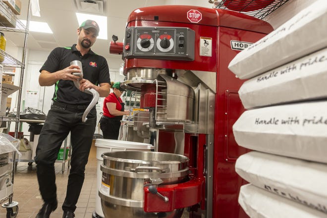 Owner Chris Ciccarelli sets up the Hobart mixer at the new Marco's Pizza restaurant in Hesperia. The restaurant makes all its pizza dough from scratch, Ciccarelli said. [James Quigg, Daily Press]