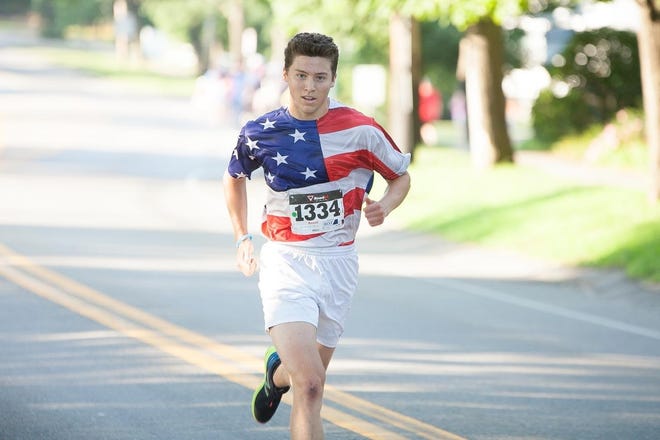 Hingham's Clark Ricciardelli, the overall winner, sprints up Main Street to catch the runner in front of him to grab victory. [COURTESY PHOTO/Joshua Ross Photography]