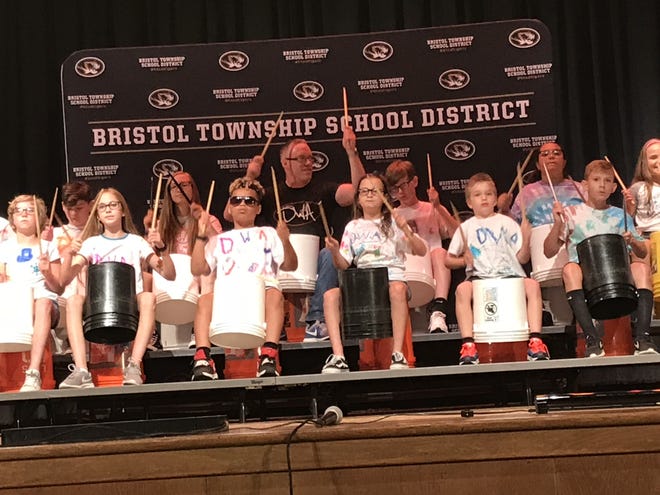 Bristol Township School District students led by teacher Kevin Travers, middle, bang out rythmic tunes on plastic buckets Tuesday as part of the culminating show of the district's two-week musical mentorship program.

[CHRIS ENGLISH/STAFF]