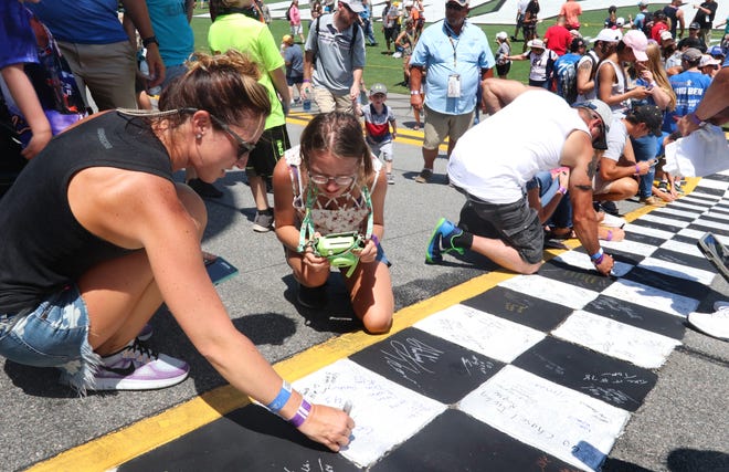 Race fans sign the start/finish line before the start of the 2018 Coke Zero Sugar 400 at Daytona International Speedway. The NASCAR race is among the factors that make July one of the busiest times of the year for tourism, said Evelyn Fine, president of Mid-Florida Marketing & Research. "In the best of all possible worlds, we would see race fans coming in for the weekend, but before that, families arriving for July 4th,” Fine said. [GetHouse Media file]