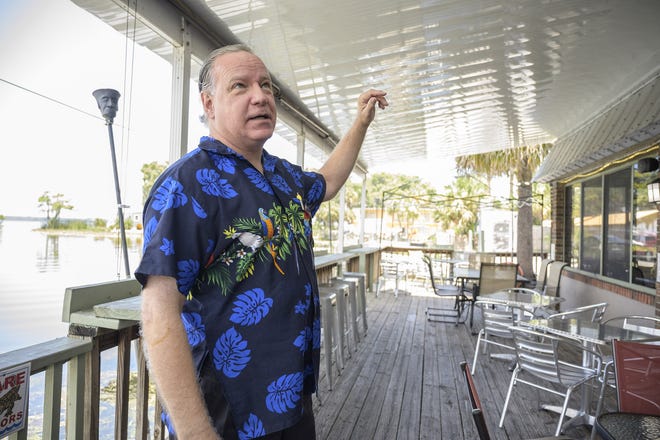 Fish Camp owner Jim Jordan shows the new patio roof after last year's tornado damaged the original one. [Cindy Sharp/Correspondent]