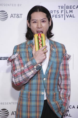Competitive eater Takeru Kobayashi poses with his cellphone at the screening for "Tribeca/ESPN Sports Film Festival Gala: The Good, The Bad, The Hungry" on April 26, 2019, during the 2019 Tribeca Film Festival in New York. The documentary premiered Tuesday, July 2, on ESPN, two days before the annual Nathan's Famous International Hot Dog Eating Contest that brought Kobayashi to prominence in the competitive eating arena. [Photo by Brent N. Clarke/Invision/AP]