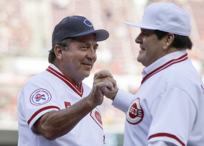 In more friendly times, Johnny Bench, left, and Pete Rose clasp hands during a 2016 ceremoney honoring the Reds' 1976 World Series champions. [AP Photo/John Minchillo]