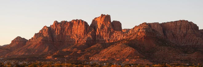 FILE - This Oct. 26, 2017, file photo shows the mountains surrounding Hildale, Ut., and its sister city, Colorado City, Ariz., at sunset, in a community on the Utah-Arizona border that has been home for more than a century to a polygamous sect that is an offshoot of mainstream Mormonism. A judge is ordering a Utah contractor with ties to a polygamous group on the Utah-Arizona border to pay a total of more than $1 million in back wages to children who prosecutors say were forced to pick pecans from 2008-2013. U.S. District Judge Tena Campbell made her Tuesday, July 2, 2019, ruling based on the Department of Labor's determination that 104 workers were eligible for back pay from Paragon Contractors. The department says the majority worked an average of six days per week and about three months each year. (AP Photo/Rick Bowmer, File)