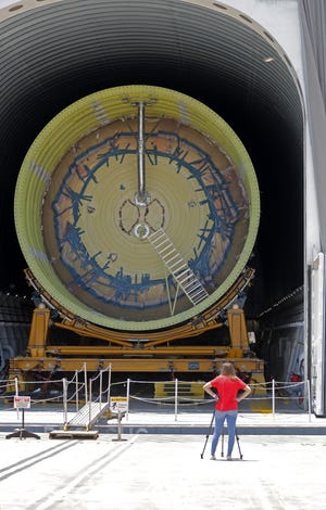 A television journalist films a test core stage for NASA's Space Launch System (SLS), being readied to transport on a barge for testing, at the NASA Michoud Assembly Facility in New Orleans, Friday, June 28, 2019. (AP Photo/Gerald Herbert)