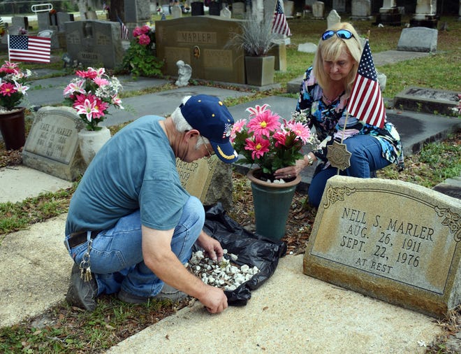 Levy and Kathy Marler-Blue work on the grave sites of some her family at Marler Memorial Cemetery earlier this week. [TINA HARBUCK/THE LOG]