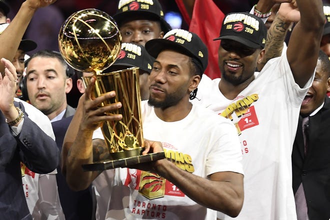 Kawhi Leonard holds the NBA Championship Trophy after leading the Raptors to the league title. [FRANK GUNN / THE CANADIAN PRESS VIA ASSOCIATED PRESS]