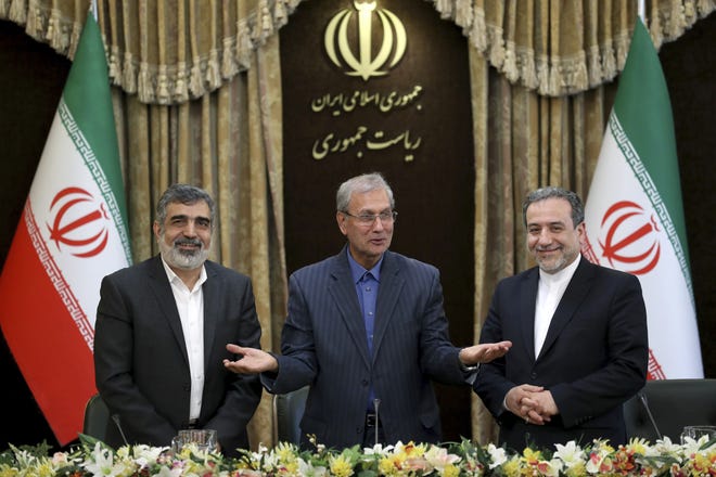 From left, spokesman for Iran's atomic agency Behrouz Kamalvandi, Iran's government spokesman Ali Rabiei and Iranian Deputy Foreign Minister Abbas Araghchi, attend a press briefing in Tehran, Iran, on Sunday. The deputy foreign minister says that his nation considers the 2015 nuclear deal with world powers to be a "valid document" and seeks its continuation. [Ebrahim Noroozi/The Associated Press]