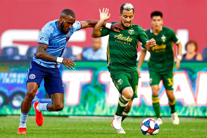 Portland Timbers midfielder Sebastian Blanco (10) battles for the ball with New York City defender Sebastien Ibeagha, left, during the second half of an MLS soccer match Sunday, July 7, 2019, in New York. (AP Photo/Adam Hunger)