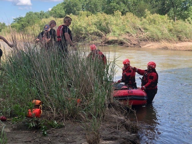 Hutchinson firefighters drop three people on a bank of the Arkansas River on Sunday after rescuing them from the river. The three attempted to float on the river but lost their inner tubes and became stranded in trees and brush on the swiftly flowing river. [Courtesy Hutchinson Fire]