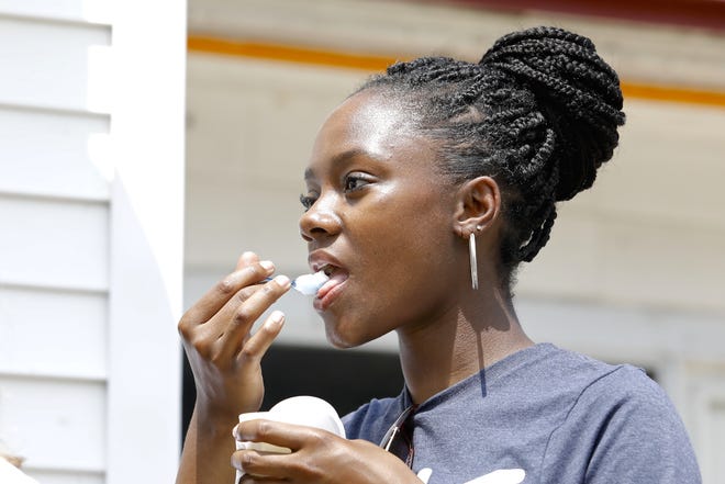 Phallen Lambert, an intern working for the city of Rockford, eats a frozen dessert Monday, July 8, 2019, during a press conference in front of Zammuto's in southwest Rockford. [SUSAN MORAN/RRSTAR.COM CORRESPONDENT]