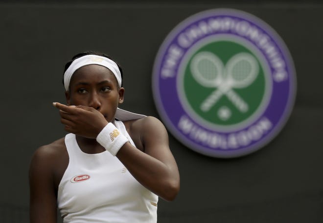 The United States' Cori "Coco" Gauff wipes her face during a singles match against Romania's Simona Halep at the Wimbledon Tennis Championships on Monday in London. [KIRSTY WIGGLESWORTH/THE ASSOCIATED PRESS]