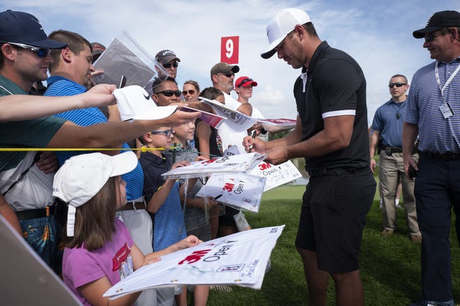 Brooks Koepka, No. 1 in the World Golf Ranking, signs autographs after practice Wednesday for the 3M golf tournament in Blaine, Minn. [JERRY HOLT/STAR TRIBUNE VIA AP]