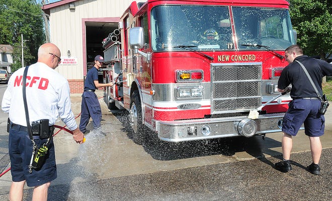 New Concord Fire Chief Brent Gates, left, assists firefighter Chris Cocca, right, and cadet Evan Fernandez in washing one of the engines in preparation of this weekend's annual fireman's festival.