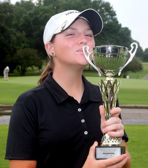 Girls overall champion Madison Tenore kisses one of two trophies she won during the 2017 Marvin DeBolt Daily News Classic golf tournament at Eglin Golf Course. [MICHAEL SNYDER/DAILY NEWS]