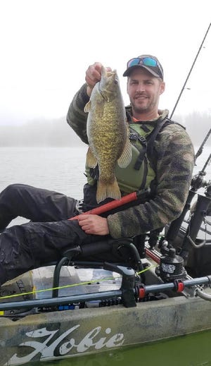 Western Pennsylvania Kayak Anglers member Greg Hall shows off a solid smallmouth. More anglers are fishing from kayaks, enjoying the accessibility, affordability, tranquility and exercise that they offer. [CONTRIBUTED/CHAD FOSTER]