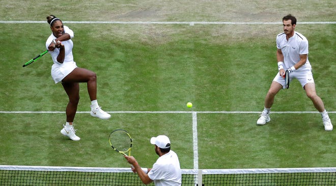 United States' Serena Williams and playing partner Britain's Andy Murray, top, in action against Fabrice Martin of France and Raquel Atawo of the United States in a mixed doubles match on day eight of the Wimbledon Tennis Championships in London, Tuesday, July 9, 2019.(AP Photo/Ben Curtis)